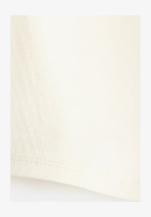 Primo piano di un tessuto color crema che mostra una fine trama a maglia e un orlo cucito sul bordo inferiore.