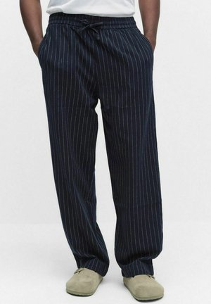 Marinblå randiga byxor med vida ben, dragsko i midjan och mjuk textur. Har vertikala vita ränder som detalj.