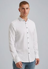 Ein weißes Langarmhemd aus glattem Stoff mit schwarzen Knöpfen an der Vorderseite und an den Manschetten sowie einem klassischen Kragendesign.