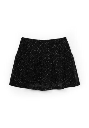 Minifalda negra con pequeños lunares blancos y un bajo con volantes acampanados, extendida sobre un fondo blanco.