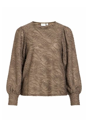 Gaiši brūna blūze ar gariem piedurknēm, vilnainu tekstūru un savāktām piedurknēm. Apaļa kakla līnija, izgatavota no mīksta auduma. Redzama zīmola etiķete.