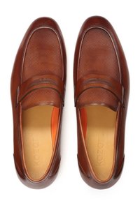 Rudi odiniai mokasinai su tekstūruotu viršumi, lygiomis detalėmis ir oranžine pamušalu. Dizainą puošia dekoratyvinė juosta priekyje.