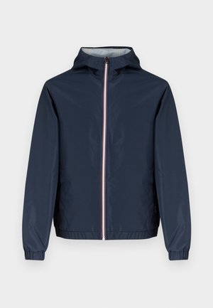 Μπλε σκούρο μπουφάν με φερμουάρ και κουκούλα, με λευκές και κόκκινες ρίγες κατά μήκος του φερμουάρ, ελαστικές μανσέτες και λεία, αδιάβροχη υφή.