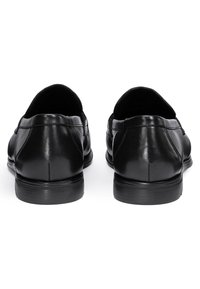 Schwarze Lederschuhe mit glatter Textur, abgerundeten Zehen, niedrigen Absätzen und dezenten Steppnähten. Die Rückansicht zeigt ein minimalistisches Design.