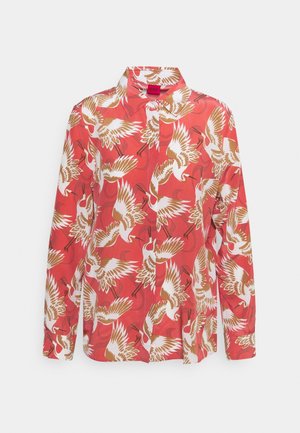 Chemise boutonnee rouge avec un motif de grues blanc et beige, manches longues, un col structuré et une texture de tissu lisse.