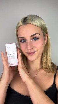 Scatola del siero Medicube Pore Pink Peptide, bianca con accenti rosa, tenuta da una persona. Presenta testo sull'etichetta e informazioni nutrizionali. Dimensione 30ml.