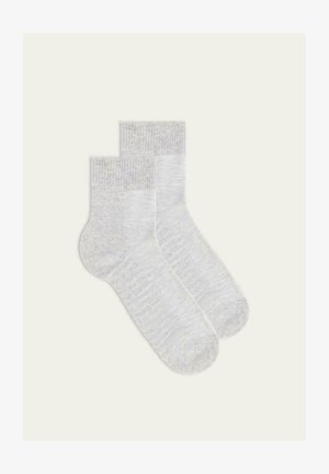 Calze di cotone grigio chiaro con polsini a coste, texture morbida, lunghezza fino al polpaccio e design minimalista, che mostrano un sottile motivo mélange.