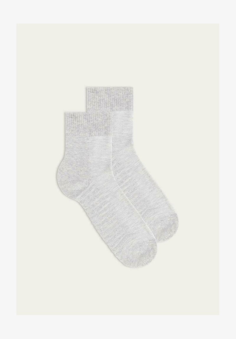 Calze di cotone grigio chiaro con polsini a coste, texture morbida, lunghezza fino al polpaccio e design minimalista, che mostrano un sottile motivo mélange.