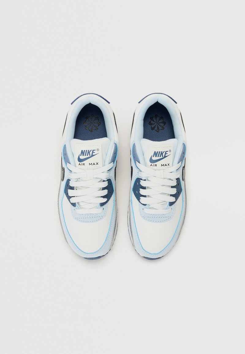 Le sneaker Nike Air Max presentano un upper bianco e azzurro chiaro con accenti blu navy, una superficie in pelle liscia, lacci piatti e un colletto imbottito.