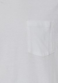T-shirt bianco realizzato in morbido cotone, con una tasca sul petto con bordo superiore dritto, texture sottile e design semplice.