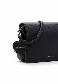 Black pebbled leather handbag with a fold-over design, featuring a heart-shaped charm, silver hardware, and embossed brand logo.