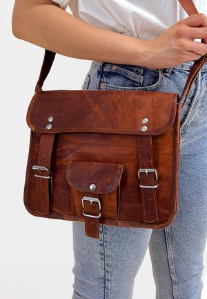 Brun läder messenger väska med klaff, silverfärgad hårdvara, framficka och justerbar rem. Texturerad yta med synliga sömnadsdetaljer.