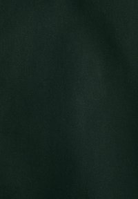 Sötét zöld szövet sima textúrával és átlós bordázott mintával. Az anyag valószínűleg egy erős szőtt textil. Nincs további látható jellemző.