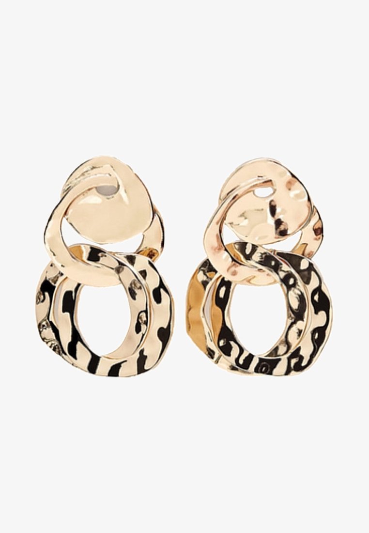 Boucles d'oreilles en métal doré avec deux formes ovales irrégulières entrelacées, la grande ovale inférieure présentant un motif martelé et texturé.