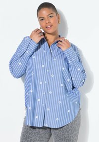 Blau-weißer gestreifter Button-up-Hemd mit floraler Stickerei, langen Ärmeln und entspannter Passform, kombiniert mit grauen Leopardenmuster-Hosen.