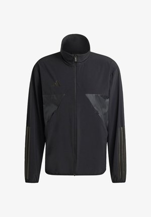 Musta takki, jossa on korkea kaulus, vetskari ja kiiltävät kontrastipaneelit rinnassa ja hihoissa, sekä teksturoitu kangas.