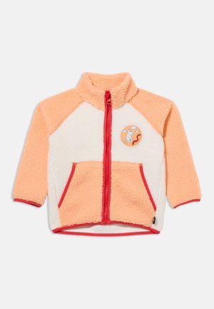 Virsiku ja valge fliisjakk punase luku ja ääristusega, kahe esitaskuga ning rindkere peal valge looma ja mardika multikapaatšiga.