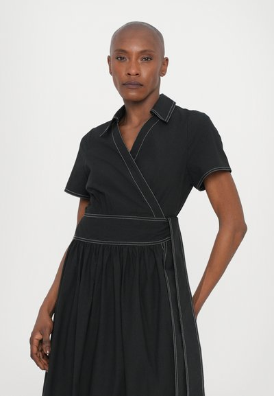 Rochie neagră cu mâneci scurte, având cusături albe în contrast și o fustă plisată, fabricată dintr-un material neted cu guler.