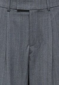 Pantalon gris à fines rayures, ajusté, avec plis et passants pour ceinture, fermeture éclair à l'avant et agrafe.