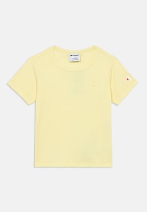 T-shirt jaune côtelé à manches courtes en coton. Présente un col rond et un petit logo brodé sur la poitrine et la manche.