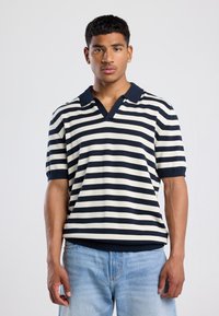 Gestreifes Poloshirt mit kurzen Ärmeln in Marineblau und Creme, mit Kragen und gerippten Bündchen. Strickmaterial mit entspannter Passform.