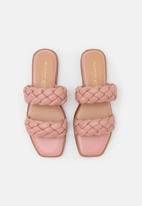 Rosa slide-sandaler med två breda flätade remmar, en slät läderliknande yta, kvadratisk tåform och ljusbrun sula. Guldlogga på inlägget.
