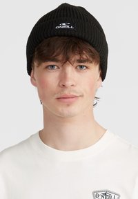 Berretto a coste nero con una piccola etichetta bianca del logo O'Neill sulla parte anteriore. Texture liscia e design aderente, adatto per un abbigliamento casual.