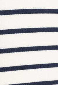 Kudottu kangas, jossa on vaihtelevia valkoisia ja tummansinisia vaakaraitoja, jotka esittelevät tasaista tekstuuria ja tasaista etäisyyttä nauhojen välillä.