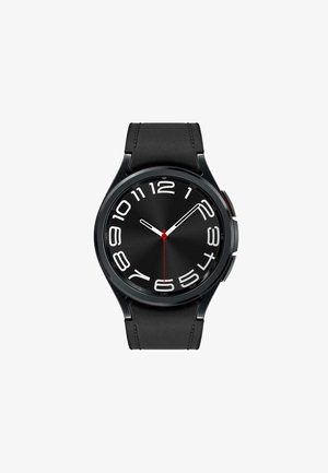 Black smartwatch with a round face, bold white numbers, and a red second hand. Features a smooth black silicone strap.