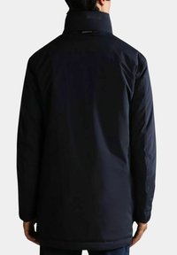 Giubbotto imbottito blu navy con colletto alto, texture liscia e forma dritta. Presenta un design minimal e cuciture nascoste.