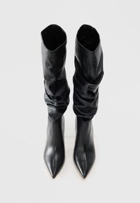 Black leather ankle boots with pointed toes and slouchy upper design. Smooth texture with an elasticized opening for easy wear.