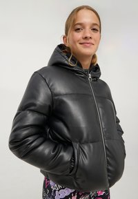 Giacca puffer nera in pelle sintetica con zip frontale, cappuccio e polsini elasticizzati. Presenta dettagli trapuntati e una vestibilità comoda.