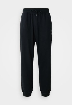 Pantalons de jogging noirs en coton doux, avec une taille élastiquée dotée d'un cordon de serrage, des poignets côtelés et un détail logo sur le côté.
