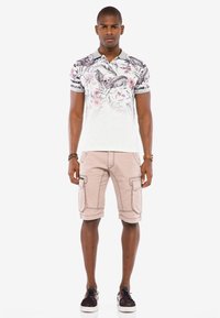 Grau-weißes Poloshirt mit floralem Muster und kurzen Ärmeln, kombiniert mit khakifarbenen Cargo-Shorts mit Taschen und gestickten Akzenten.