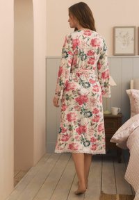 Cvečni kimono z dolgimi rokavi, ki ima rožnate, modre in zelene cvetove na kremnem ozadju, čipkast rob na dnu in kravato v pasu.