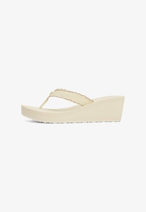 Sandalias de cuña beige con una correa texturizada, con un diseño tipo chancla y una suela de goma acanalada para un mejor agarre.