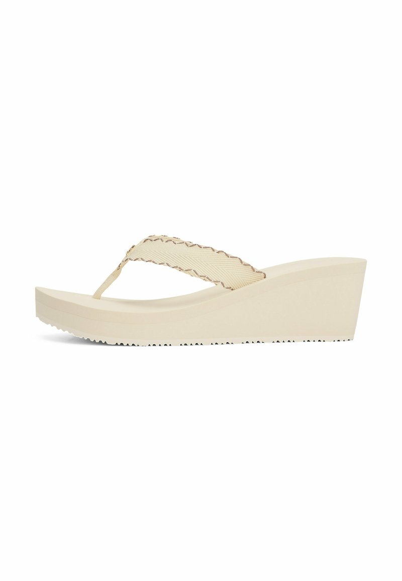Sandalias de cuña beige con una correa texturizada, con un diseño tipo chancla y una suela de goma acanalada para un mejor agarre.
