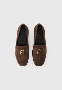 Brūni zamša loafers ar franjām un zelta toņu aksesuāriem. Iekšzolei ir iegravēts "FURLA" zīmola nosaukums.