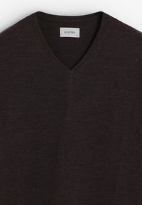 Donkerbruine V-hals trui gemaakt van fijne brei-stof. Heeft een subtiele logo aan de linkerzijde en een standaard pasvorm. De stoftextuur is glad.