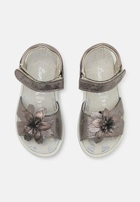Metallisk bronsefargede sandaler med doble stropper og blomsterdetalj. Myk fotseng med sommerfugl mønster; justerbare borrelås-lukker.