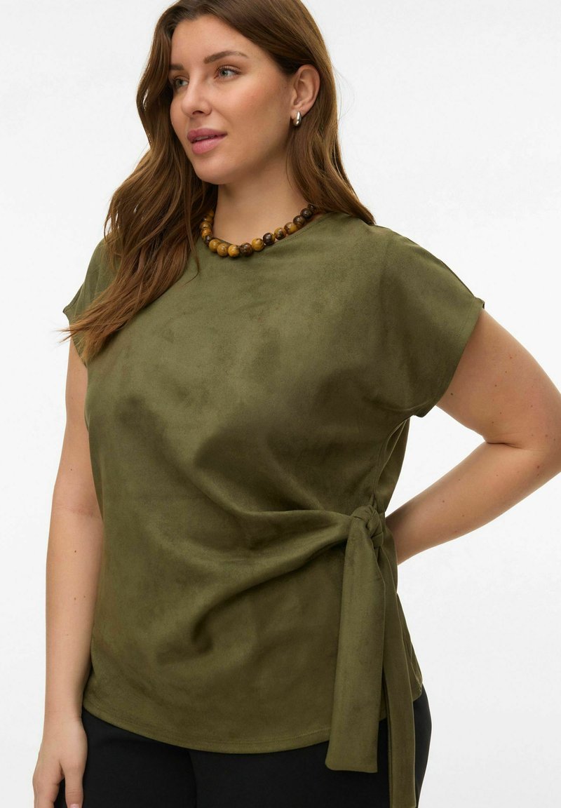 Haut à manches courtes vert olive en tissu doux effet suédé, avec un détail noué à la taille et une coupe décontractée.