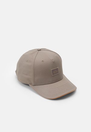 Beige Baseballkappe mit gesteppten Paneelen, Belüftungsösen, gebogenem Schirm und kleinem rechteckigem Logopatch vorne.