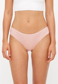 Light pink cotton brief with elastic waistband featuring "GUESS" logo. Smooth texture and classic cut, designed for comfort and fit.