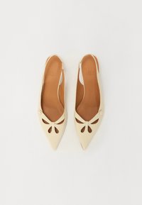 Beżowe skórzane buty na obcasie typu slingback z ostro zakończonym noskiem, dekoracyjną kokardą i wycięciem. Gładka tekstura i jasnobrązowa wkładka widoczna wewnątrz.