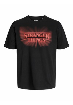 Must värvi puuvillane T-särk, millel on punane "STRANGER THINGS" logo plahvatusefektiga. Ümmargune kaelus, lühikesed varrukad ja mugav lõige.