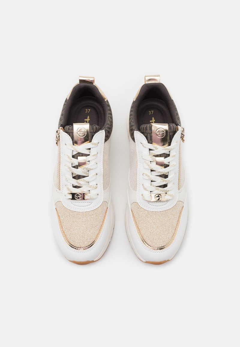 Sneakers met een crème en beige gaas bovenwerk, witte leren accenten, gouden hardware en gestructureerde donkerbruine details; inclusief veters en ritssluiting.