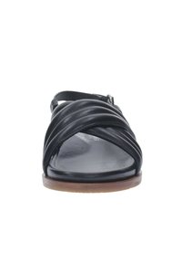 Sandalo in pelle nera con un design a cinturino attorcigliato, punta rotonda e suola marrone. Cinturino alla caviglia regolabile per una vestibilità sicura.