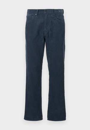 Tamno plave kord traperice ravnog kroja, s prednjim džepovima, dugmetom za zakopčavanje i suptilnom rebrastom teksturicom.