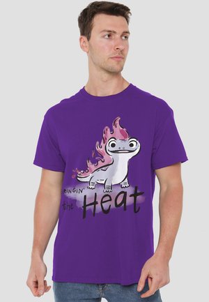 Purple cotton t-shirt featuring a cartoon lizard with flame details and the text "Ringin' the Heat" in a bold, black font.
