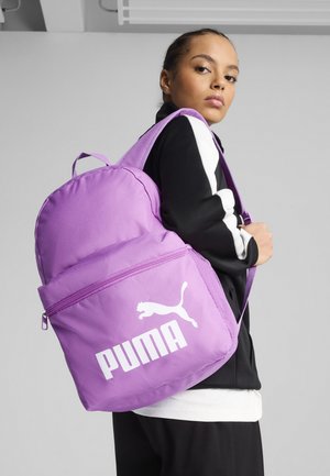 Zaino viola realizzato in tessuto resistente, dotato di una grande tasca frontale, dettaglio con cerniera e un logo Puma bianco prominente con un design di un gatto che salta.